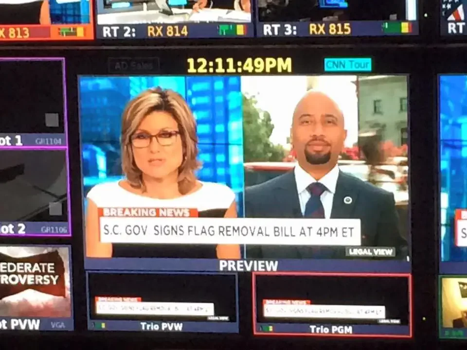 A news broadcast shows Cezar McKnight discussing South Carolina's flag removal bill.